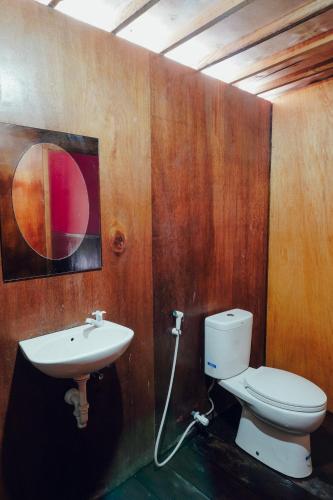a bathroom with a toilet and a sink at Leaf Coco Bungalow in Gili Air