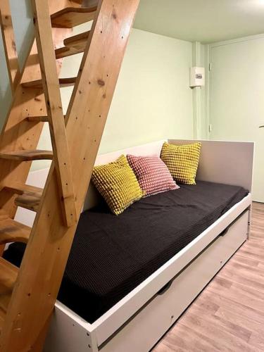 Ce lit se trouve dans un dortoir doté d'une échelle en bois. dans l'établissement Brouettes 3 : Studio Mezzanine, à Rouen