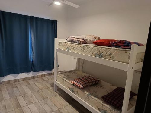 聖何塞的住宿－CATA 1. SAN JOSE ENTRE RIOS，配有蓝色窗帘的客房内的两张双层床