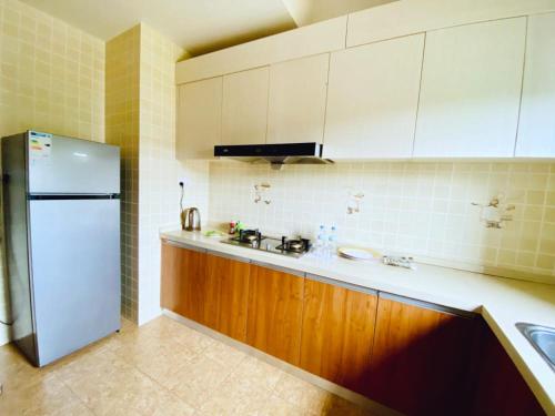 a kitchen with a white refrigerator and wooden cabinets at Century Park Hotel & Residences in Kigali