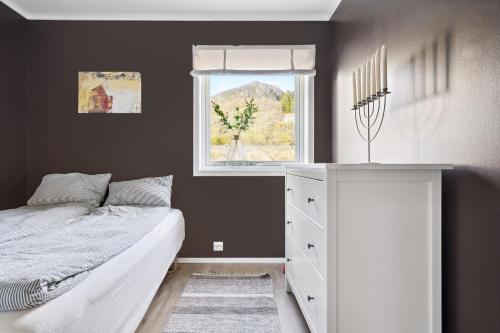 um quarto com uma cama branca e uma janela em Large villa in Lofoten with fantastic views - 4 bedrooms and 9 beds. em Stamsund