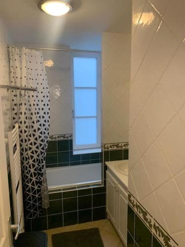 La salle de bains est pourvue d'une fenêtre, d'une baignoire et d'un lavabo. dans l'établissement T4 en centre-ville, proche gare avec parking, à Valenciennes