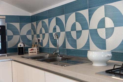 a kitchen with a sink and blue and white tiles at REGINNA LIGHTHOUSE in Maiori