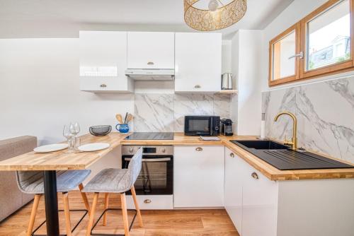 une cuisine avec des armoires blanches et une table avec des chaises dans l'établissement ¤Maison¤ / standing / terrasse et cœur de ville, à Angers