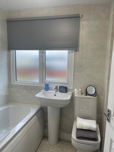 a bathroom with a sink and a toilet and a window at Oyster Retreat in Amble