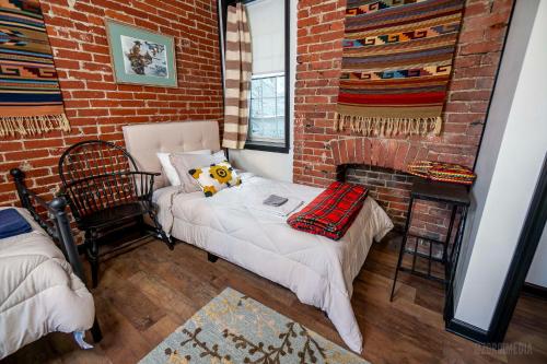 una habitación con una cama y una pared de ladrillo en The Pittsburgh Hideaway-Amazing View-3 Bedrooms, en Pittsburgh