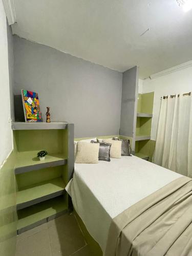 ein kleines Schlafzimmer mit einem Bett und Regalen in der Unterkunft claussporto in Porto De Galinhas
