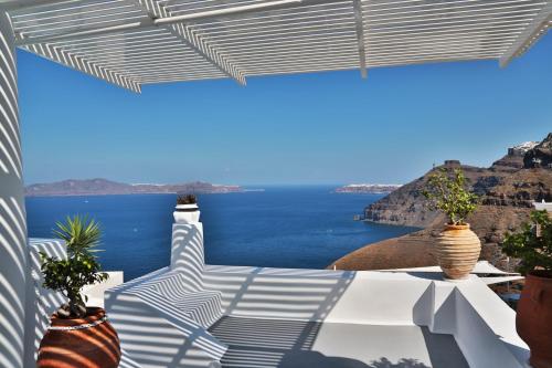 a view of the ocean from a patio with potted plants at Trieris Villa & Suites in Fira