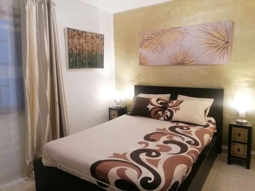 een slaapkamer met een bed met een bruine en witte deken bij Casa Naturaleza 2 in Caleta De Fuste