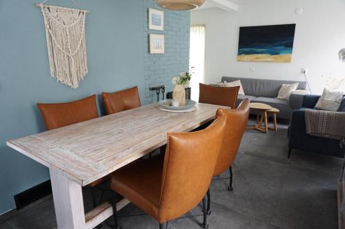 a dining room with a wooden table and chairs at Kustverhuur, Park Schoneveld, Zeester 46 in Breskens