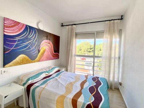 a bedroom with a bed and a painting on the wall at Bonito bungalow en la playa in Puebla de Farnals