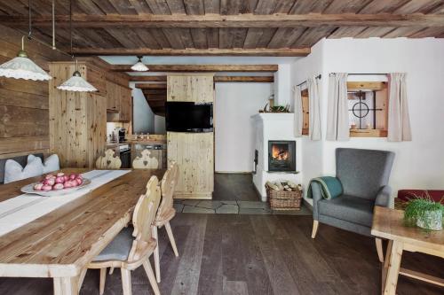 eine Küche und ein Esszimmer mit einem Holztisch und Stühlen in der Unterkunft Feriendorf Holzlebn in Großarl