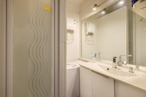 une salle de bain avec une douche avec un lavabo et un miroir dans l'établissement Studio - Mer Soleil Confort, à Antibes