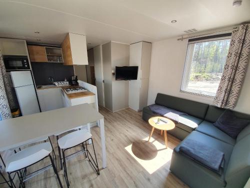 una pequeña sala de estar con sofá y mesa. en Ferienpark Auf dem Simpel - Heide-Lodge 2 en Soltau