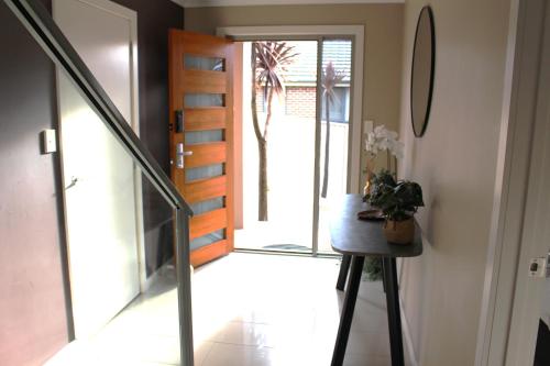 a hallway with a glass door and a stair case at Sunny Modern 3 Bedroom Townhouse in Newnham