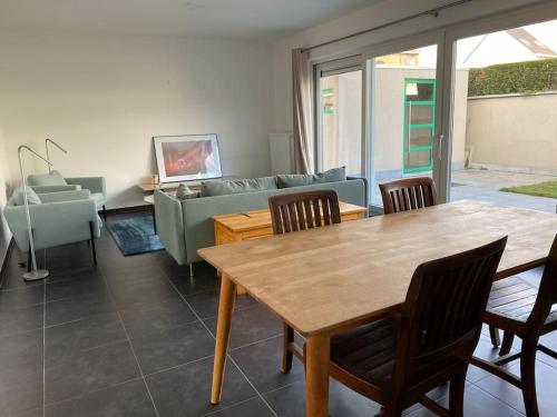 a living room with a table and a couch at Woning met 4 slaapkamers in Zelzate