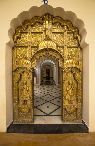 an ornate gold gate with two angels on it at Umaid Haveli-A Heritage Style Hotel & Resort in Jaipur