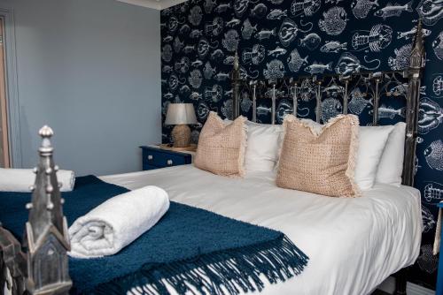 een slaapkamer met een bed met zwart en wit behang bij Seaside Cottage - Beautiful Views - Hot Tub 