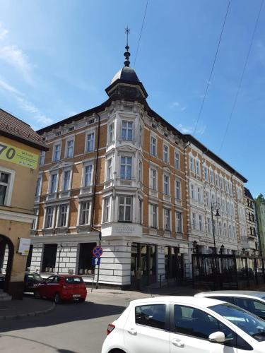 a large building with cars parked in front of it at Apartament centrum-rynek Gorzów Wlkp. in Gorzów Wielkopolski