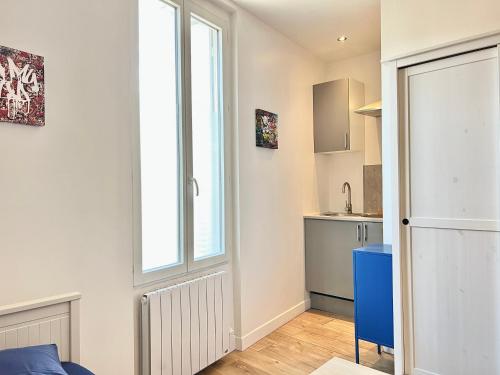 Il comprend une petite cuisine avec une fenêtre et une porte. dans l'établissement Le Kansas ~ Studio à 5 min du centre ville ~ FIBRE, à Poitiers