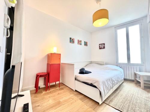- une chambre avec un lit et un tabouret rouge dans l'établissement Le Kansas ~ Studio à 5 min du centre ville ~ FIBRE, à Poitiers