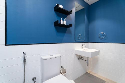 a bathroom with a white toilet and a sink at Nasma Luxury Stays - Home-Style 2BR Apartment with a Balcony View in Dubai
