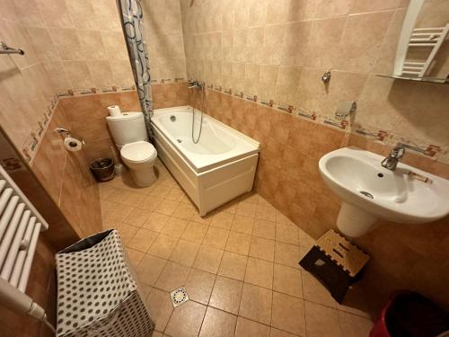 La salle de bains est pourvue d'un lavabo, de toilettes et d'une baignoire. dans l'établissement Top Lodge twobedroom apartment, à Bansko