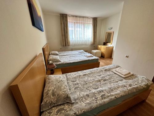 a room with two beds in a room with a window at Top Lodge twobedroom apartment in Bansko