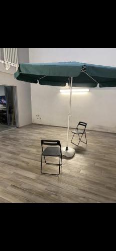 two chairs and an umbrella in an empty room at SMAC in Andria