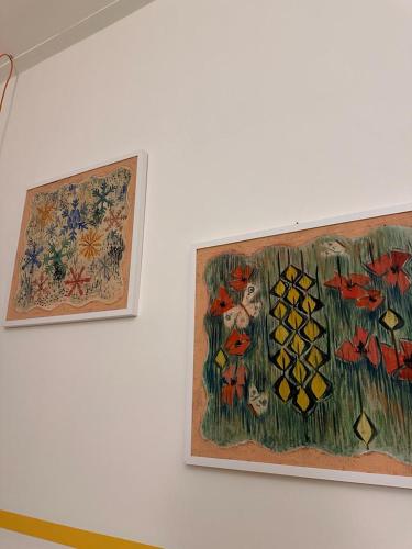 two paintings of flowers on a wall at Le Case di LuVi in Nola