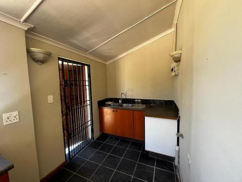 uma cozinha com um lavatório e uma bancada em BDN Backpackers em Joanesburgo