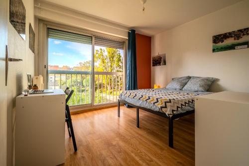 1 dormitorio con cama y ventana grande en Grande Chambre privée chez l'habitant en Montpellier