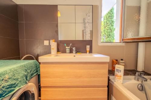 a bathroom with a sink and a washing machine at Grande Chambre privée chez l'habitant in Montpellier