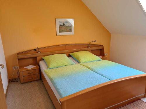 a bedroom with a bed with a wooden head board at Ferienwohnungen Meyerhof_ 55116 in Filsum