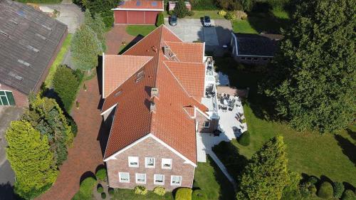 an overhead view of a large house with a red roof at Ferienwohnungen Meyerhof_ 55116 in Filsum
