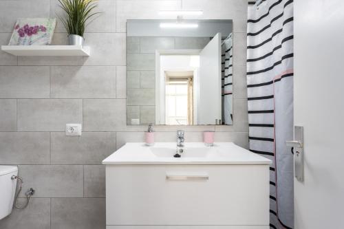 een badkamer met een witte wastafel en een spiegel bij Sea Lovers El Médano in El Médano
