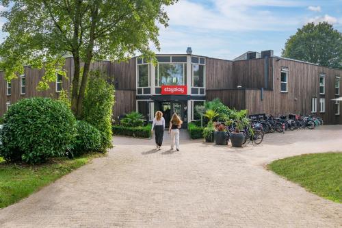 two women walking in front of a building at Stayokay Hostel Dordrecht - Nationaal Park De Biesbosch in Dordrecht