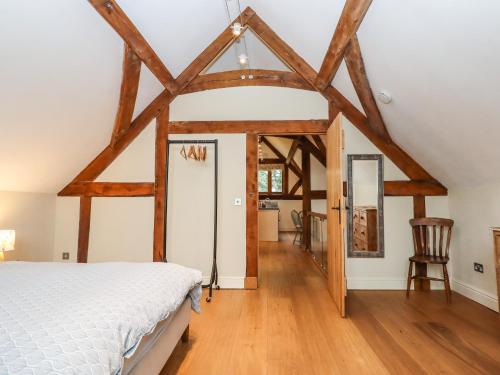 a bedroom with a bed in a room with wooden beams at The Acorn Barn in Exeter