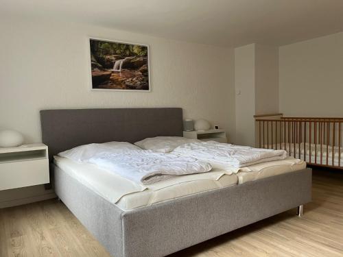 ein Schlafzimmer mit einem Bett in einem Zimmer mit einem Kinderbett in der Unterkunft Waldhaus Harz, mit Pool und Sauna in Stecklenberg