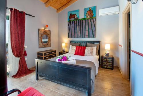a bedroom with a large bed with red pillows at Lilac Lilium Artistsvillas in Gaios