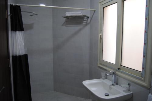 a bathroom with a sink and a window and a shower at Villa 3 Studios in 6th Of October