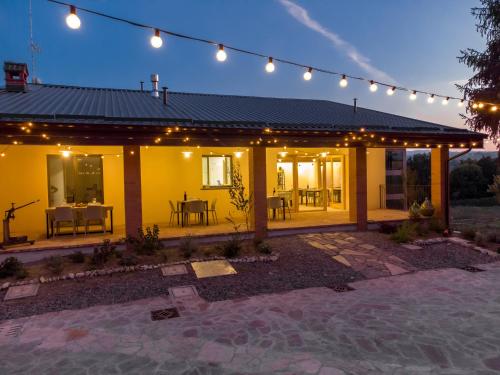 a yellow house with lights and a patio at Agriturismo Cà Vida in Ziano Piacentino