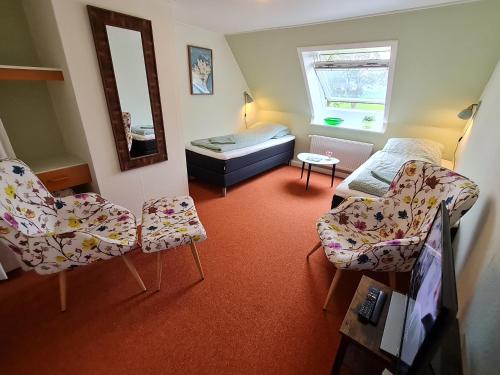 um quarto com duas cadeiras e uma cama e um espelho em KirkeLy Bed and Breakfast em Vester Ulslev
