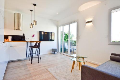 kuchnia i salon ze szklanym stołem w obiekcie Le Flore - Appartement neuf - Cannes Center w Cannes