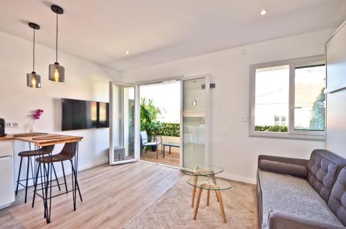 un salon avec un canapé et une table dans l'établissement Le Flore - Appartement neuf - Cannes Center, à Cannes