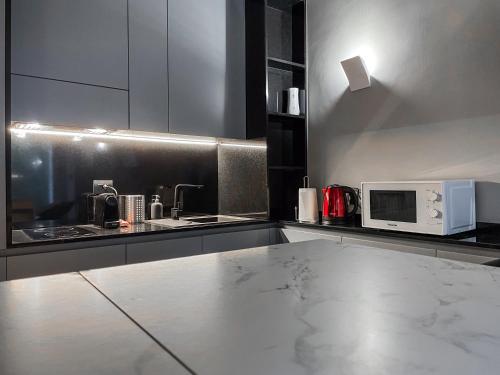 una cucina con lavandino e forno a microonde di Bubi House Moscova a Milano