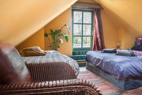 a bedroom with two beds and a chair and a window at BoHo Experience Summerhouse in Kockengen