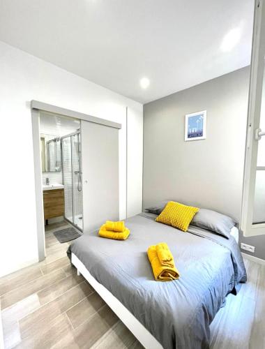 um quarto com uma cama com almofadas amarelas em Congrès Résidence em Nice