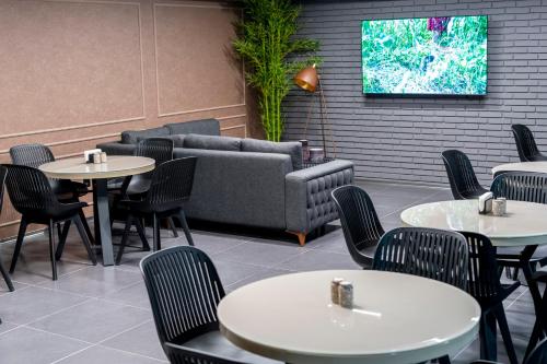 a restaurant with tables and chairs and a couch at Hotel Best Tbilisi in Tbilisi City