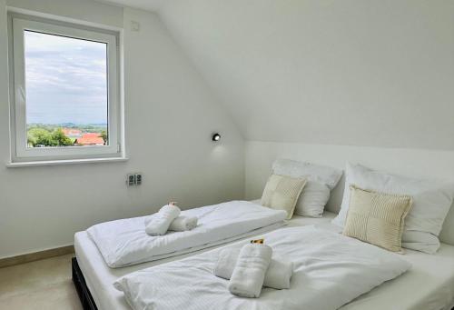 2 weiße Betten in einem Zimmer mit Fenster in der Unterkunft Bergblick-Apartment IStayUnixI Seenähe-Workspace-Netflix I KEINE Monteure in Friedrichshafen